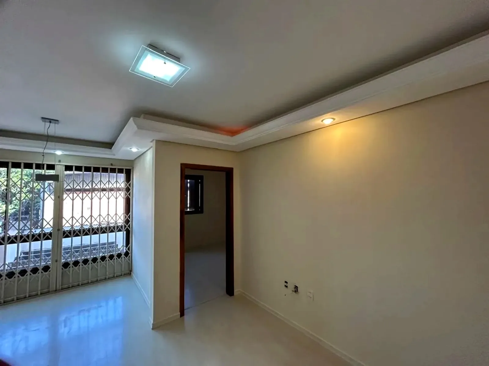 Sala com janela gradeada e acesso aos quartos