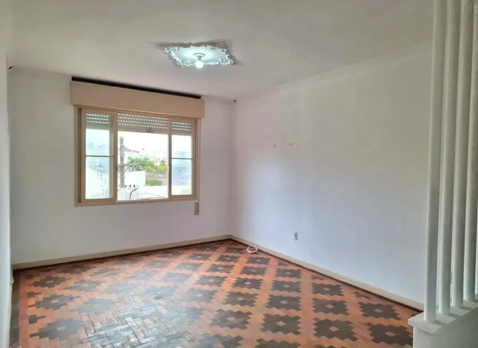 Living com parquet desenhado e janela ampla